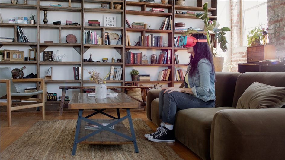 Девушка сидит в виртуальных очках на диване в комнате