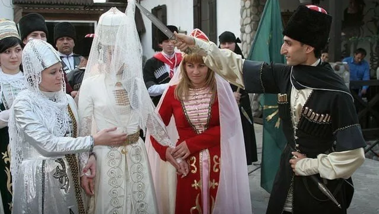 Жених держит над головой невесты обрядовую палку
