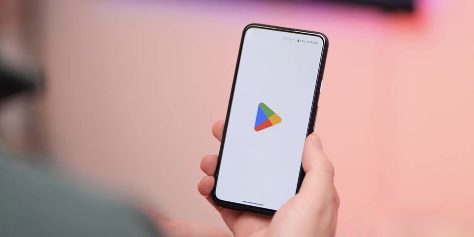 смартфон с логотипом Google Play в руке пользователя