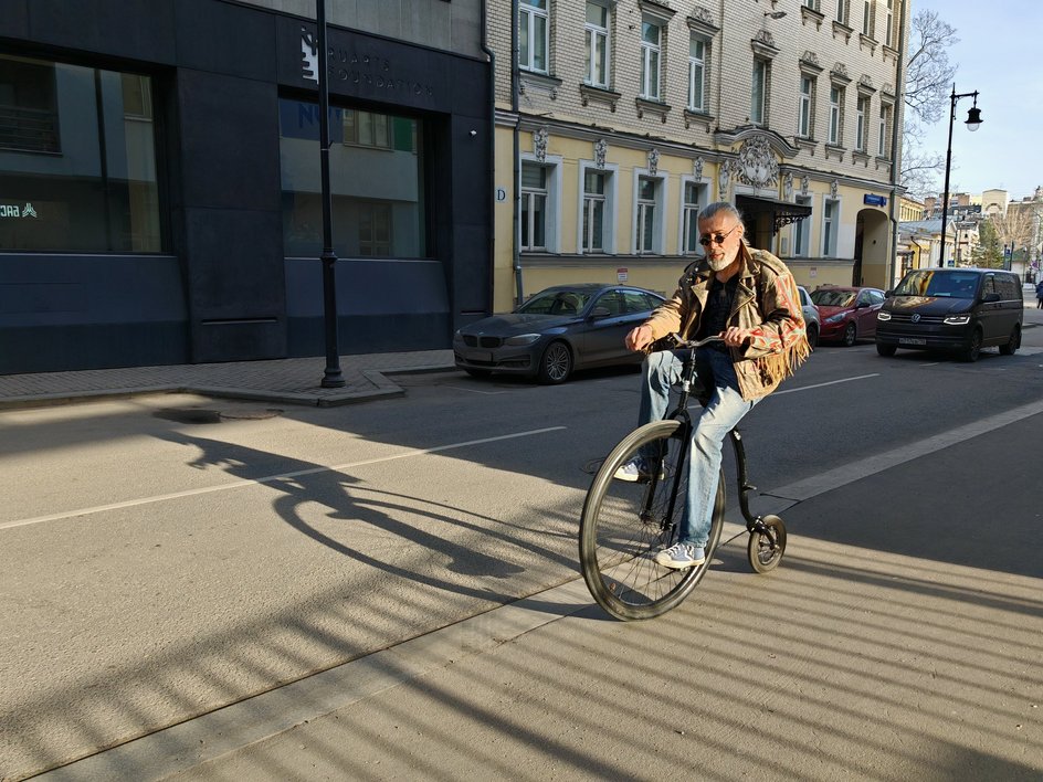 Мужчина едет на велосипеде по улице
