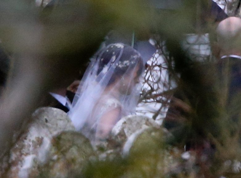 Однако несколько фото, сделанных папарацци, все же просочились в СМИ — благодаря им мы можем увидеть часть свадебного наряда невесты