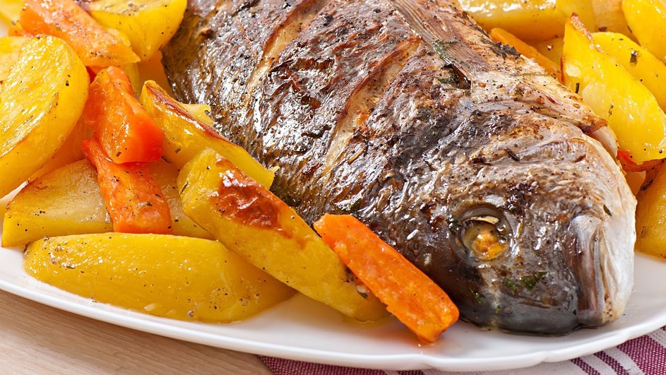 Рыба, приготовленная в фольге с овощами, крупным планом Рыба, приготовленная в фольге с овощами, крупным планом