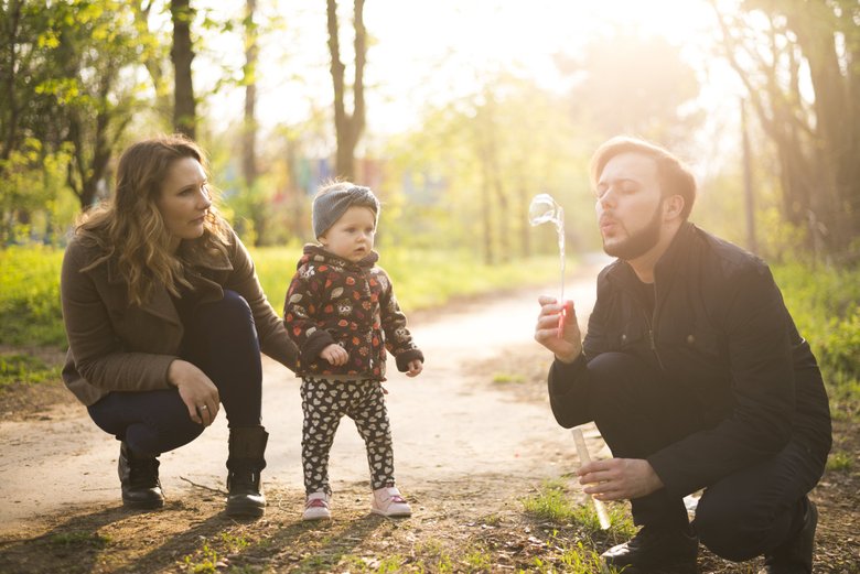 Родители гуляют с ребенком Родители гуляют с ребенком