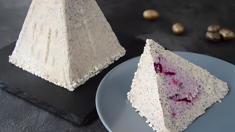 Кусочек творожной пасхи лежит на тарелке рядом с другим кусочком Кусочек творожной пасхи лежит на тарелке рядом с другим кусочком
