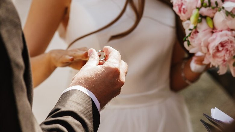 Жених надевает кольцо на палец невесте