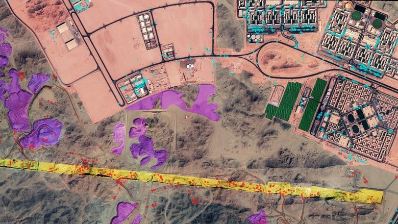 На спутниковых снимках видно оборудование для строительства (красный цвет), насыпи земли (фиолетовый), след «Линии» (желтый) и главный строительный городок (синий, розовый и зеленый). Фото: Soar Urban / Gizmodo